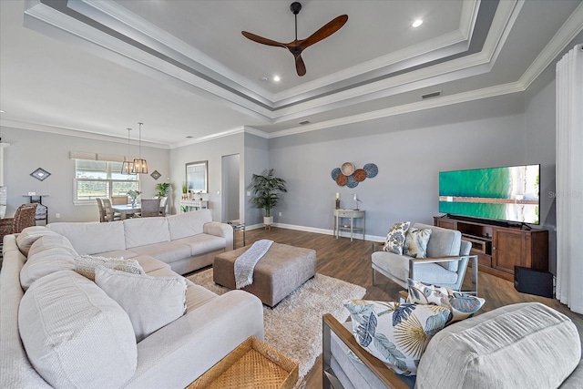 29527 Leah Rd, Punta Gorda, FL 33982 - living room featuring wood finished floors, ceiling fan, a tray ceiling, and ornamental molding
