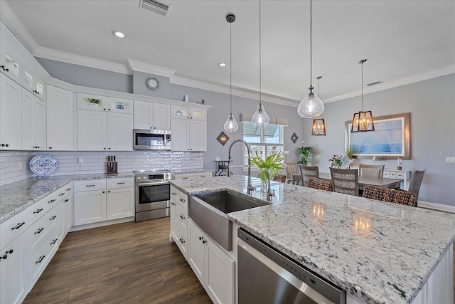 29527 Leah Rd, Punta Gorda, FL 33982 - kitchen with stainless steel appliances, crown molding, decorative backsplash, glass insert cabinets, and white cabinetry