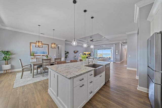 29527 Leah Rd, Punta Gorda, FL 33982 - kitchen with stainless steel appliances, ornamental molding, white cabinets, wood finished floors, and decorative light fixtures