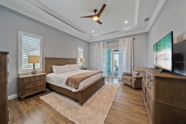 29527 Leah Rd, Punta Gorda, FL 33982 - bedroom featuring a tray ceiling, access to exterior, ornamental molding, dark wood-type flooring, and ceiling fan