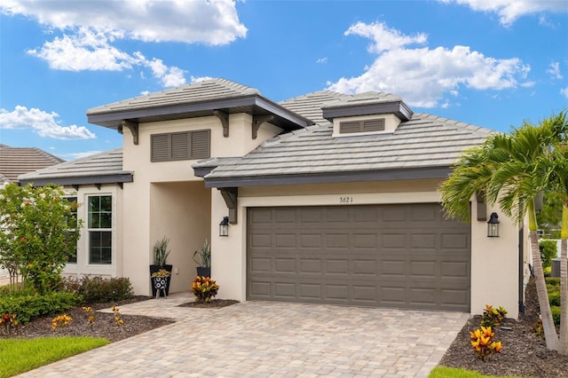 3621 Wild Blossom Pl, Parrish, FL 34219 - view of front facade featuring stucco siding, a garage, decorative driveway, and a tiled roof
