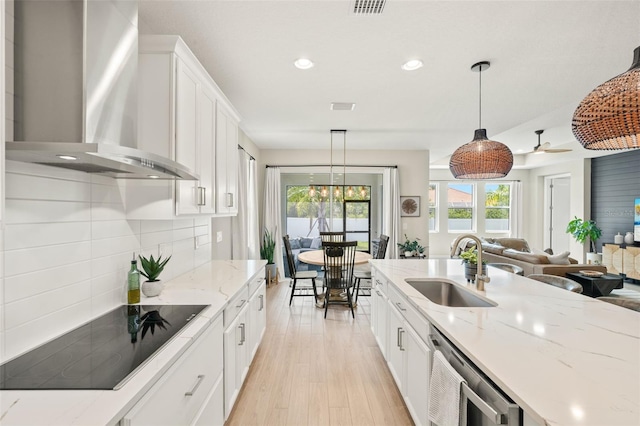 3621 Wild Blossom Pl, Parrish, FL 34219 - kitchen featuring wall chimney range hood, black electric stovetop, open floor plan, white cabinets, and dishwashing machine