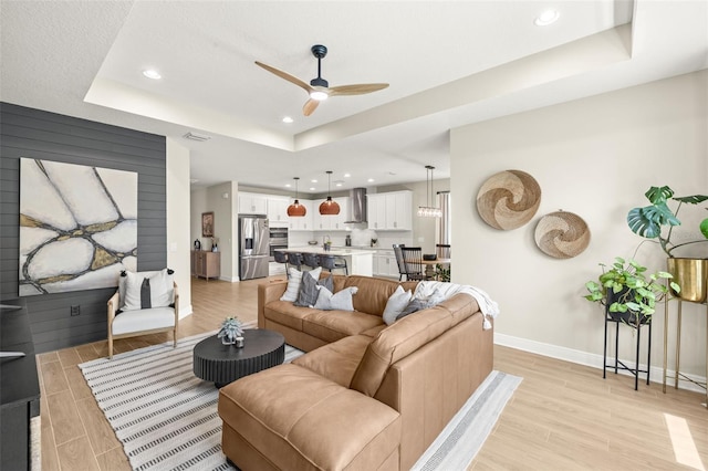3621 Wild Blossom Pl, Parrish, FL 34219 - living area with light wood-style flooring, ceiling fan, a raised ceiling, and recessed lighting