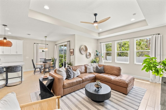 3621 Wild Blossom Pl, Parrish, FL 34219 - living area with a tray ceiling, a ceiling fan, light wood-style flooring, and recessed lighting