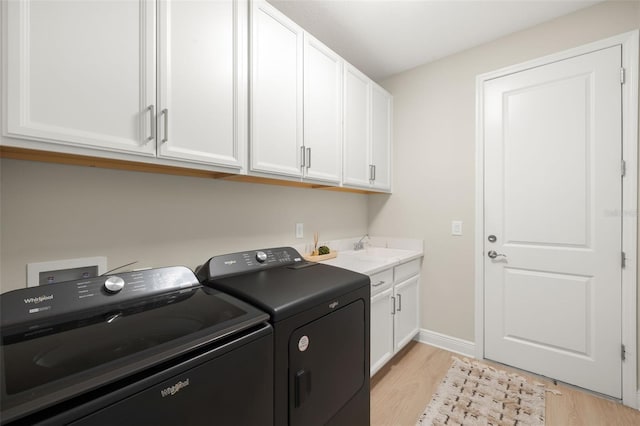 3621 Wild Blossom Pl, Parrish, FL 34219 - laundry area featuring independent washer and dryer, light wood-style floors, and cabinet space