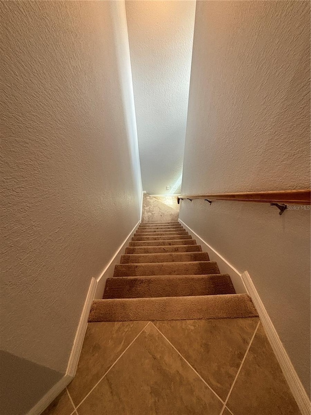 10054 Crooked Creek Dr Unit 201, Venice, FL 34293 - stairway featuring tile patterned floors and a textured wall