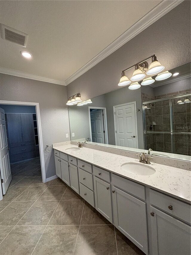 10054 Crooked Creek Dr Unit 201, Venice, FL 34293 - bathroom with ornamental molding, double vanity, a shower stall, tile patterned floors, and a closet