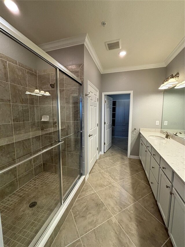 10054 Crooked Creek Dr Unit 201, Venice, FL 34293 - bathroom featuring crown molding, vanity, a stall shower, tile patterned floors, and recessed lighting
