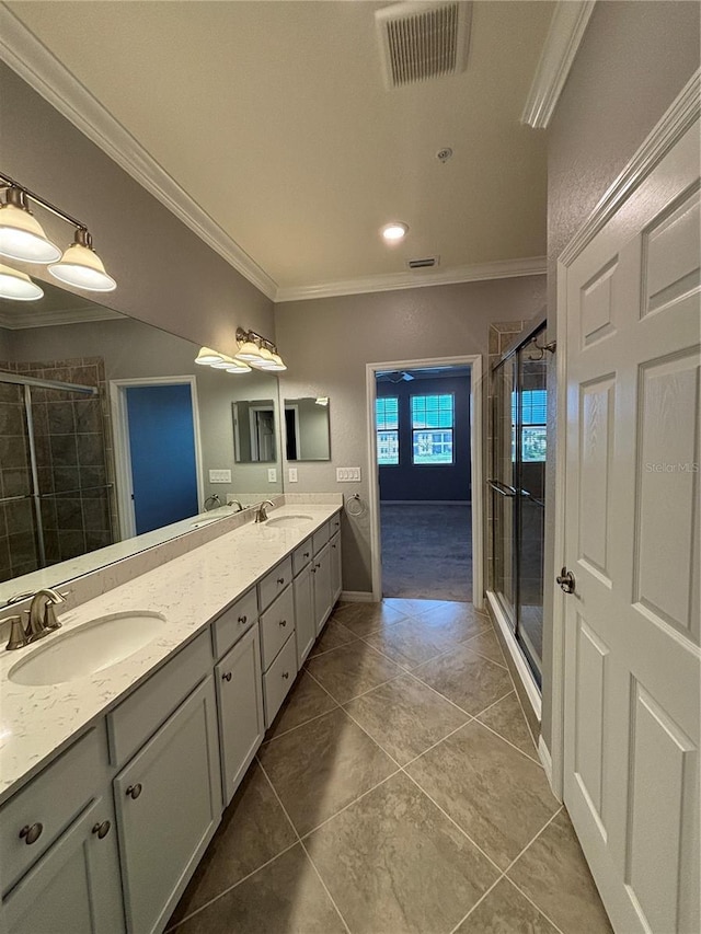 10054 Crooked Creek Dr Unit 201, Venice, FL 34293 - bathroom featuring crown molding, double vanity, a shower stall, and tile patterned flooring