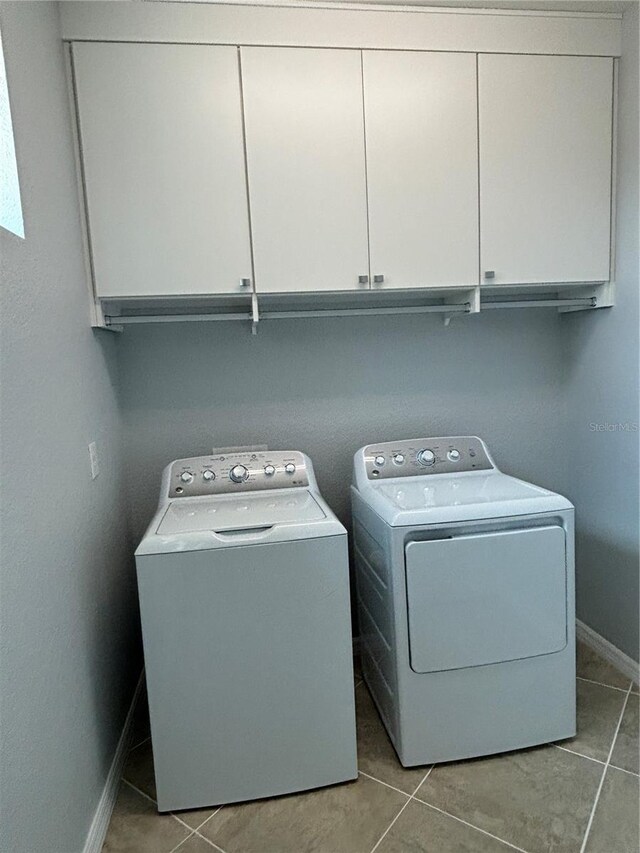 10054 Crooked Creek Dr Unit 201, Venice, FL 34293 - laundry room featuring cabinet space, washer and dryer, and tile patterned flooring