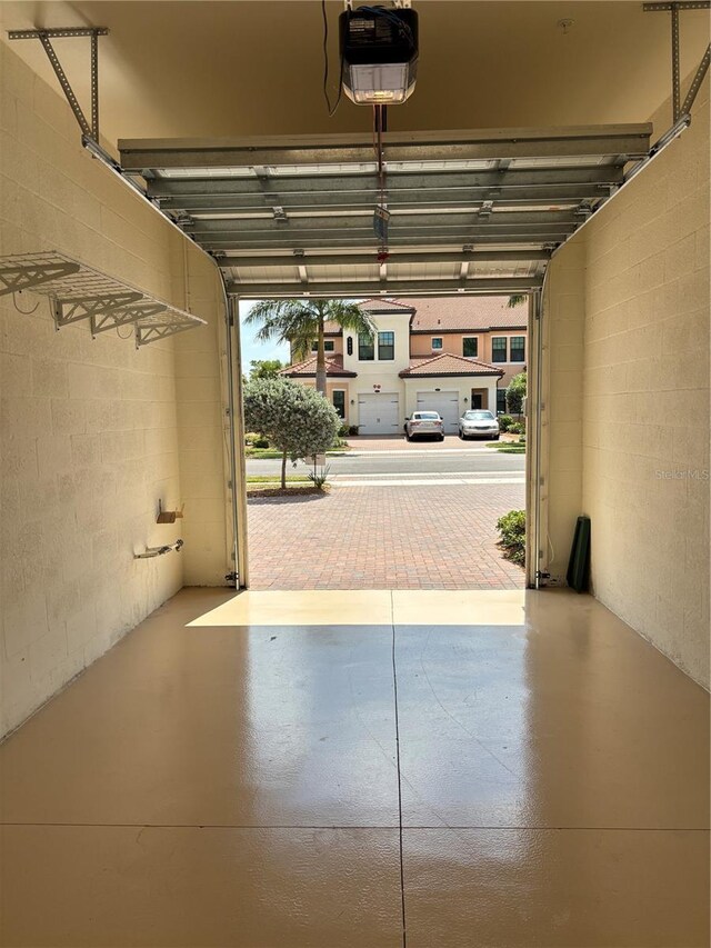 10054 Crooked Creek Dr Unit 201, Venice, FL 34293 - garage featuring a garage door opener and concrete block wall