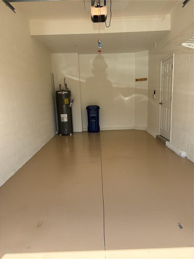 10054 Crooked Creek Dr Unit 201, Venice, FL 34293 - garage featuring electric water heater, a garage door opener, and concrete block wall