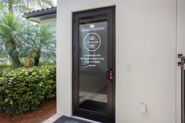 10054 Crooked Creek Dr Unit 201, Venice, FL 34293 - view of exterior entry featuring stucco siding