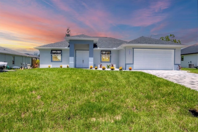 10443 Riverside Rd, Port Charlotte, FL 33981 - prairie-style home with stucco siding, a garage, a front yard, decorative driveway, and roof with shingles