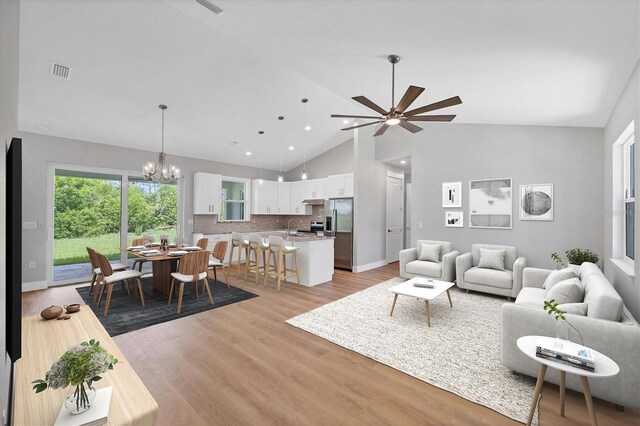 10443 Riverside Rd, Port Charlotte, FL 33981 - living area featuring high vaulted ceiling, a chandelier, light wood-type flooring, ceiling fan, and recessed lighting