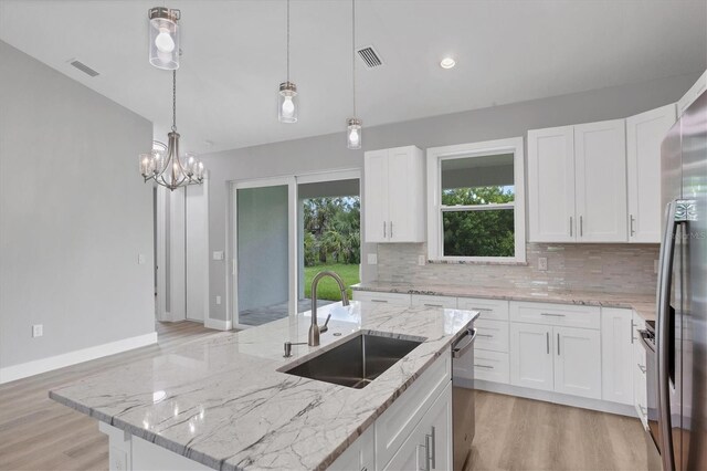 10443 Riverside Rd, Port Charlotte, FL 33981 - kitchen with decorative backsplash, light wood-style floors, appliances with stainless steel finishes, decorative light fixtures, and recessed lighting