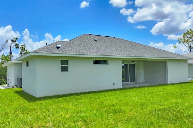 10443 Riverside Rd, Port Charlotte, FL 33981 - rear view of property with stucco siding, roof with shingles, a lawn, and a ceiling fan