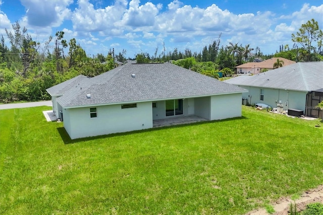 10443 Riverside Rd, Port Charlotte, FL 33981 - rear view of house with a yard, a shingled roof, stucco siding, and a patio area