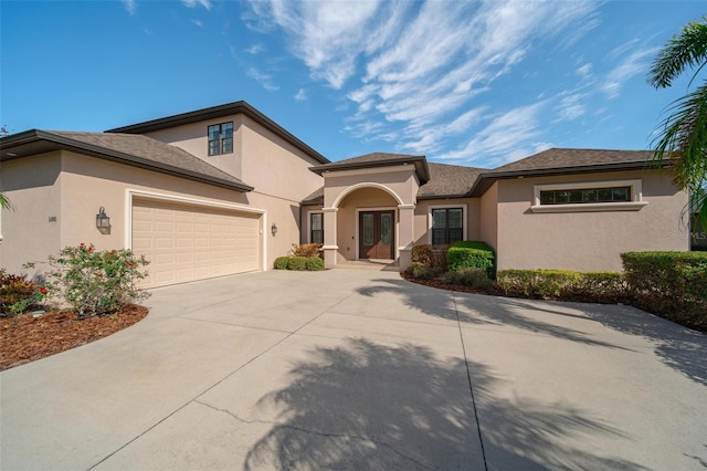 14901 17th Ave E, Bradenton, FL 34212 - view of front facade featuring french doors, concrete driveway, stucco siding, and an attached garage