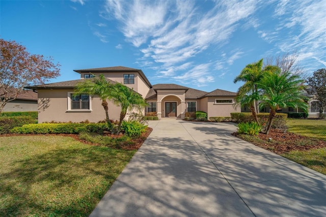 14901 17th Ave E, Bradenton, FL 34212 - mediterranean / spanish-style home with stucco siding, a front lawn, and driveway