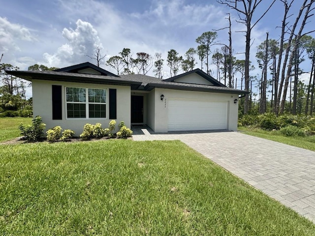 2425 Maclachlan St, Port Charlotte, FL 33953 - ranch-style house with stucco siding, decorative driveway, a garage, and a front lawn