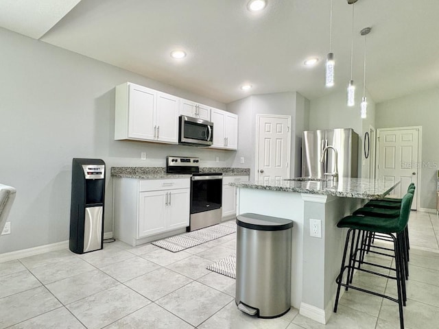 2425 Maclachlan St, Port Charlotte, FL 33953 - kitchen featuring stainless steel appliances, light stone counters, a breakfast bar, white cabinets, and recessed lighting