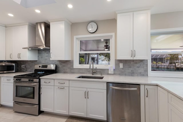 3715 101st St W, Bradenton, FL 34210 - kitchen with appliances with stainless steel finishes, wall chimney exhaust hood, backsplash, white cabinetry, and recessed lighting