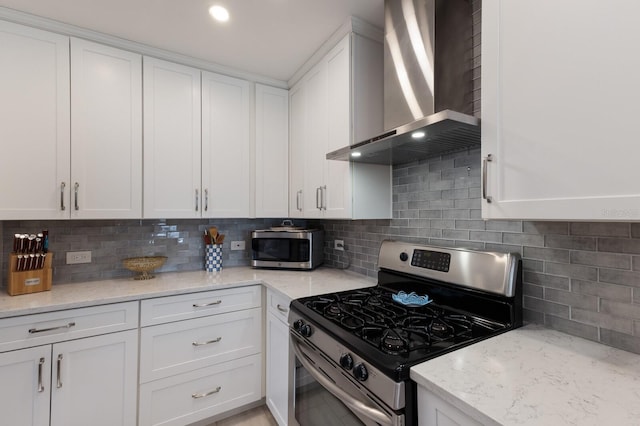 3715 101st St W, Bradenton, FL 34210 - kitchen with stainless steel appliances, wall chimney range hood, white cabinets, backsplash, and light stone countertops