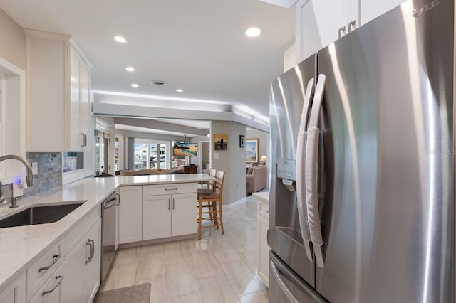 3715 101st St W, Bradenton, FL 34210 - kitchen featuring stainless steel appliances, recessed lighting, a peninsula, light stone counters, and white cabinetry