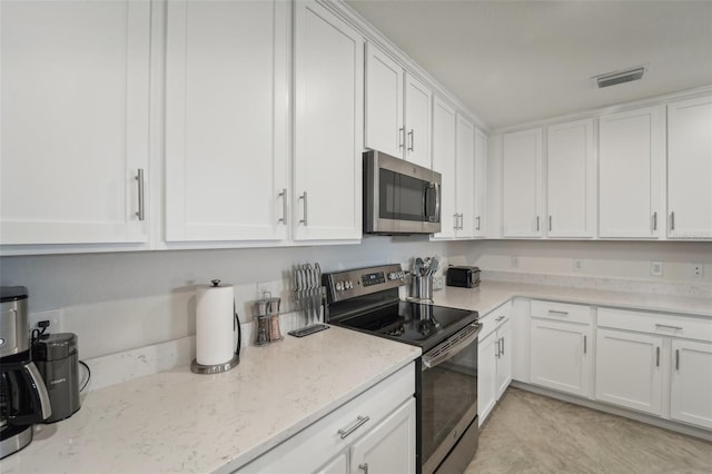 850 Tidewater Shores Loop Unit 102, Bradenton, FL 34208 - kitchen with stainless steel appliances, white cabinetry, and light stone counters
