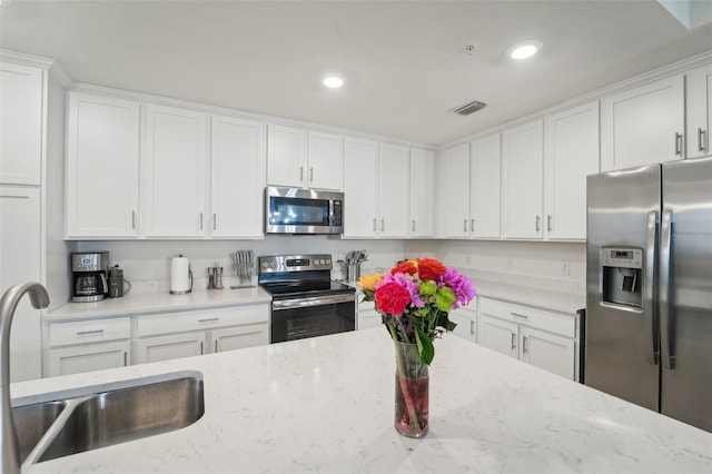 850 Tidewater Shores Loop Unit 102, Bradenton, FL 34208 - kitchen featuring appliances with stainless steel finishes, white cabinets, recessed lighting, and light stone counters