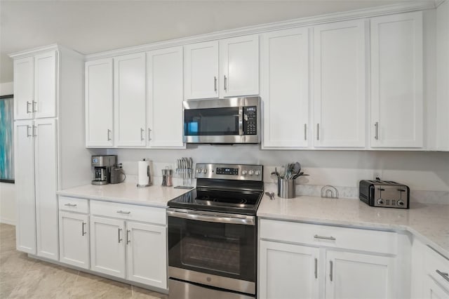 850 Tidewater Shores Loop Unit 102, Bradenton, FL 34208 - kitchen with appliances with stainless steel finishes, white cabinets, and light stone counters