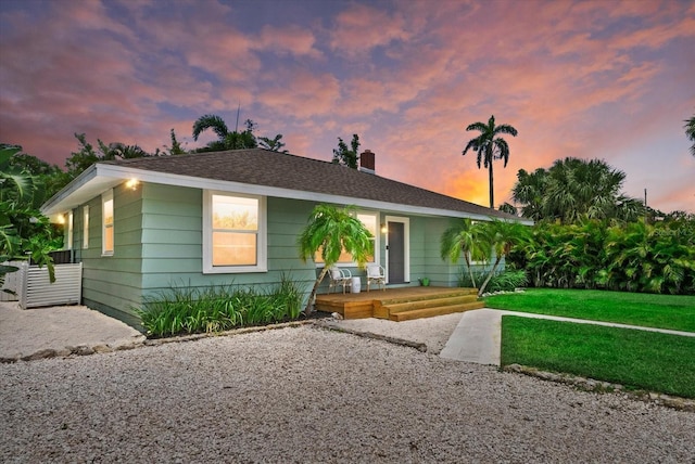 1051 Indian Beach Dr, Sarasota, FL 34234 - view of front of house with a lawn and a chimney