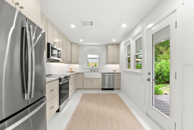 1051 Indian Beach Dr, Sarasota, FL 34234 - kitchen with appliances with stainless steel finishes, tasteful backsplash, light countertops, recessed lighting, and cream cabinetry