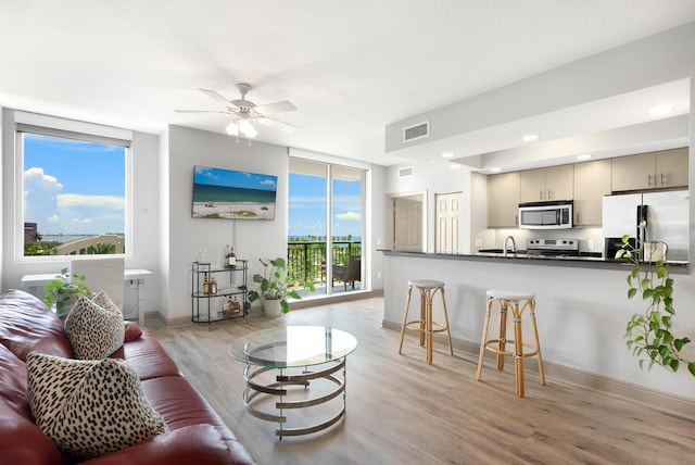 800 N Tamiami Trl Unit 405, Sarasota, FL 34236 - living room featuring light wood finished floors, a ceiling fan, recessed lighting, and expansive windows