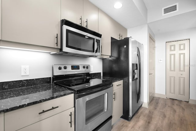 800 N Tamiami Trl Unit 405, Sarasota, FL 34236 - kitchen featuring stainless steel appliances, light wood finished floors, dark stone counters, and recessed lighting