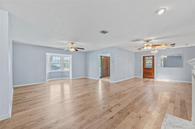 6103 6th Ave NW, Bradenton, FL 34209 - unfurnished living room featuring ceiling fan, a textured ceiling, light wood finished floors, and a fireplace
