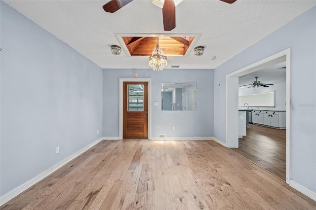 6103 6th Ave NW, Bradenton, FL 34209 - spare room featuring ceiling fan, wood finished floors, a textured ceiling, and a chandelier
