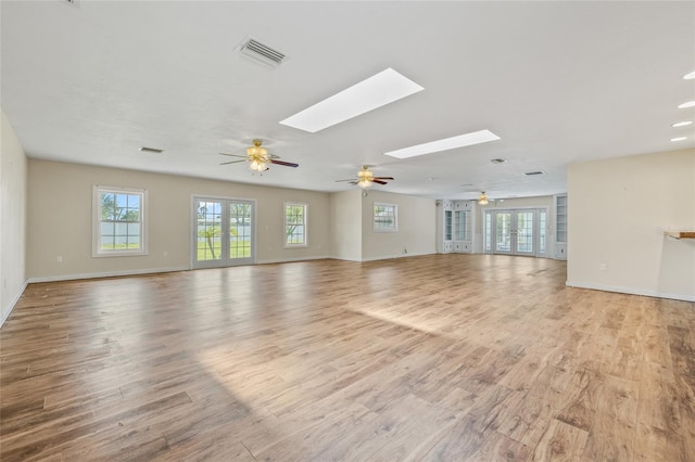 6103 6th Ave NW, Bradenton, FL 34209 - unfurnished living room featuring ceiling fan, light wood finished floors, and a skylight