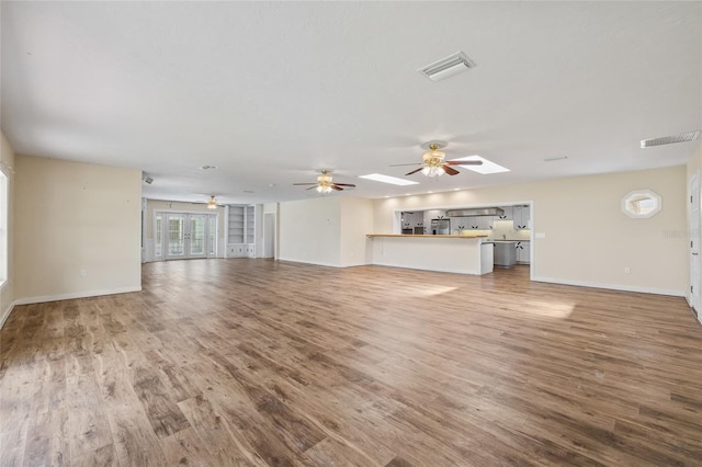 6103 6th Ave NW, Bradenton, FL 34209 - unfurnished living room featuring wood finished floors, a ceiling fan, and french doors