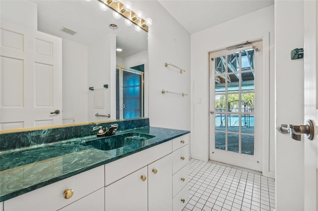 6103 6th Ave NW, Bradenton, FL 34209 - full bathroom with vanity, a stall shower, tile patterned floors, and a textured ceiling