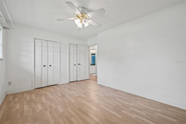 6103 6th Ave NW, Bradenton, FL 34209 - unfurnished bedroom with light wood finished floors, multiple closets, a textured ceiling, and ceiling fan