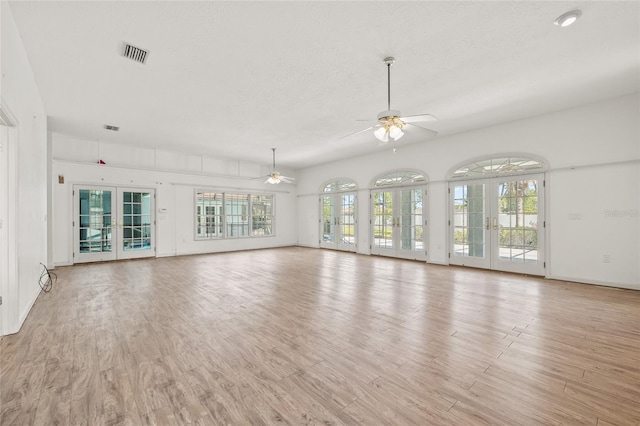 6103 6th Ave NW, Bradenton, FL 34209 - unfurnished living room with healthy amount of natural light, a ceiling fan, light wood-type flooring, and french doors