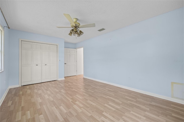 6103 6th Ave NW, Bradenton, FL 34209 - unfurnished bedroom with light wood finished floors, a closet, a textured ceiling, and a ceiling fan