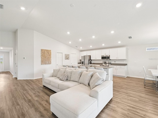 6528 166th Pl E, Parrish, FL 34219 - living room with vaulted ceiling, light wood-style flooring, and recessed lighting