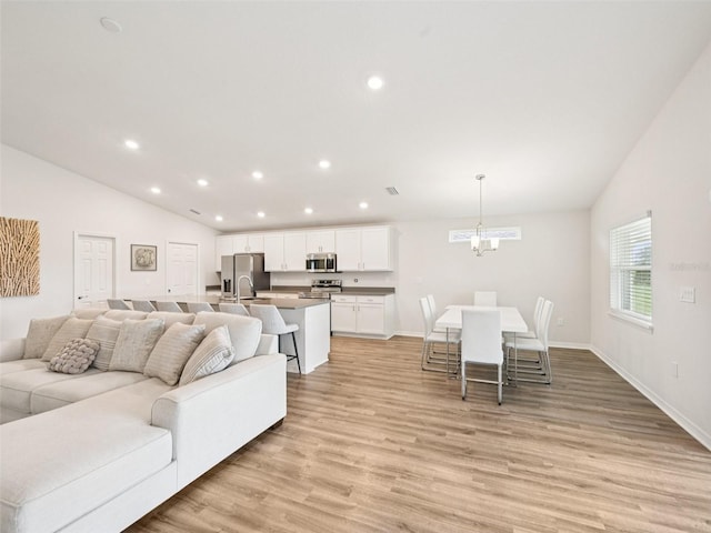6528 166th Pl E, Parrish, FL 34219 - living room with lofted ceiling, light wood-style floors, a chandelier, and recessed lighting