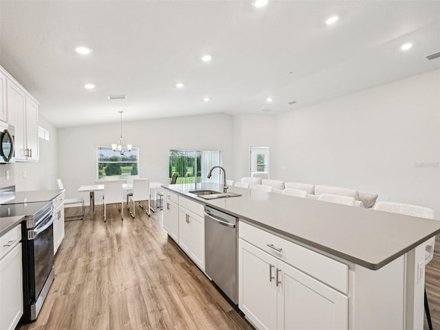 6528 166th Pl E, Parrish, FL 34219 - kitchen featuring appliances with stainless steel finishes, light wood-type flooring, recessed lighting, white cabinetry, and an island with sink