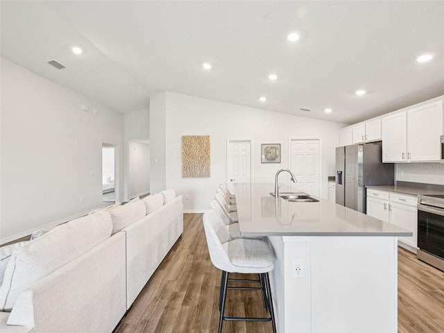 6528 166th Pl E, Parrish, FL 34219 - kitchen featuring appliances with stainless steel finishes, open floor plan, lofted ceiling, recessed lighting, and an island with sink