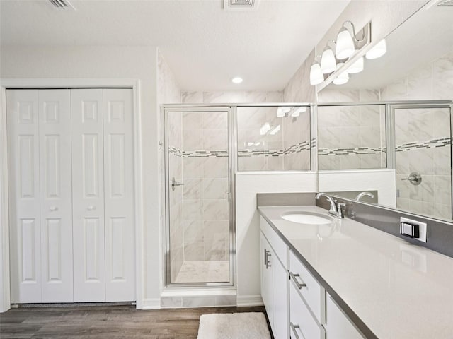 6528 166th Pl E, Parrish, FL 34219 - bathroom with a closet, vanity, a shower stall, wood finished floors, and recessed lighting