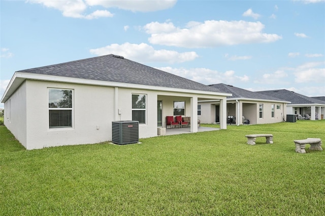 6528 166th Pl E, Parrish, FL 34219 - rear view of house with a patio, roof with shingles, a yard, and stucco siding